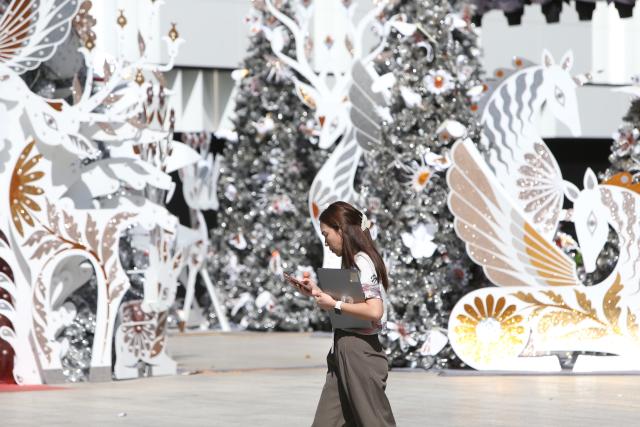 (260106) -- BANGKOK, Jan. 6, 2026 (Xinhua) -- A woman walks past festive decorations at a shopping mall in Bangkok, Thailand, Jan. 6, 2026. Thailand's business sentiment weakened in December 2025 as confidence in the manufacturing sector faded amid continued improvements in the non-manufacturing sector, data from the central bank showed on Monday. (Xinhua/Rachen Sageamsak)