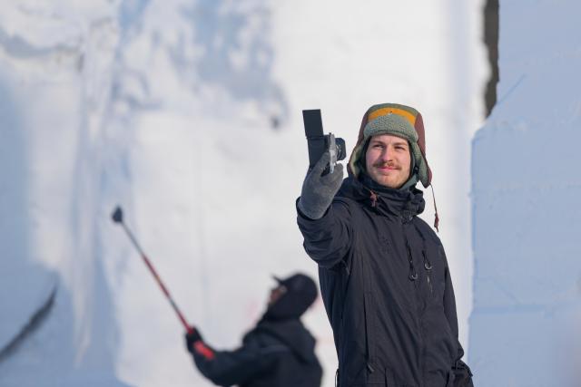 (260106) -- HARBIN, Jan. 6, 2026 (Xinhua) -- A contestant takes photos at the compound for the Sun Island International Snow Sculpture Art Expo in Harbin, northeast China's Heilongjiang Province, Jan. 6, 2026. The 28th Harbin international snow sculpture competition kicked off here on Tuesday, attracting 25 teams of snow sculptors from 13 countries. (Xinhua/Wang Jianwei)