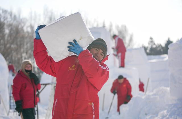 (260106) -- HARBIN, Jan. 6, 2026 (Xinhua) -- A contestant moves a snow block at the compound for the Sun Island International Snow Sculpture Art Expo in Harbin, northeast China's Heilongjiang Province, Jan. 6, 2026. The 28th Harbin international snow sculpture competition kicked off here on Tuesday, attracting 25 teams of snow sculptors from 13 countries. (Xinhua/Wang Jianwei)