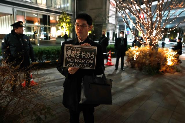 (260106) -- TOKYO, Jan. 6, 2026 (Xinhua) -- A man holds a slogan in support of Venezuela during a protest in front of the U.S. embassy in Tokyo, Japan, Jan. 6, 2026. The U.S. military struck Venezuela on Saturday, capturing President Maduro and his wife and transferring them to the United States. (Xinhua/Jia Haocheng)