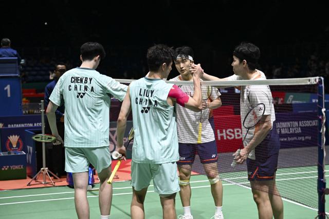 (260106) -- KUALA LUMPUR, Jan. 6, 2026 (Xinhua) -- Chen Boyang (1st L)/Liu Yi (2nd L) of China shake hands with Kim Won Ho (2nd R)/Seo Seung Jae of South Korea after their men's doubles round of 32 match at the Malaysia Open 2026 badminton tournament in Kuala Lumpur, Malaysia, Jan. 6, 2026. (Xinhua/Cheng Yiheng)