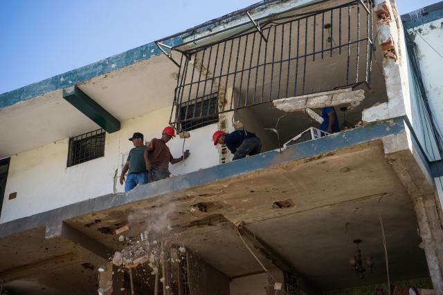 (260106) -- CATIA LA MAR, Jan. 6, 2026 (Xinhua) -- Workers operate in a building damaged by a U.S. airstrike in the Soublette neighborhood of Catia La Mar, Venezuela, Jan. 5, 2026. (Str/Xinhua)