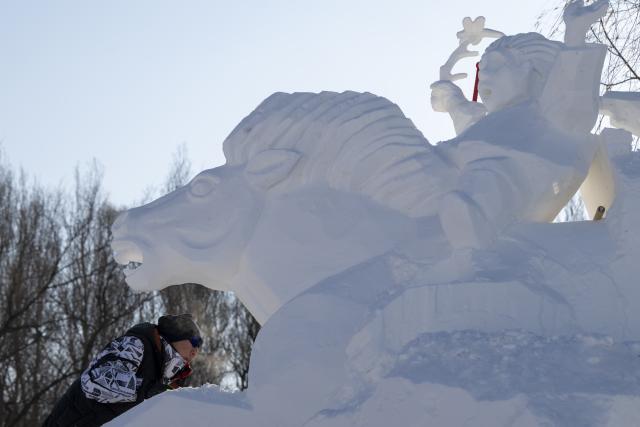 (260107) -- HARBIN, Jan. 7, 2026 (Xinhua) -- A contestant works on a snow sculpture at the compound for the Sun Island International Snow Sculpture Art Expo in Harbin, northeast China's Heilongjiang Province, Jan. 7, 2026. The 28th Harbin international snow sculpture competition kicked off here on Tuesday, attracting 25 teams of snow sculptors from 13 countries. Various snow sculpture works have begun to take shape on Wednesday. (Xinhua/Zhang Tao)