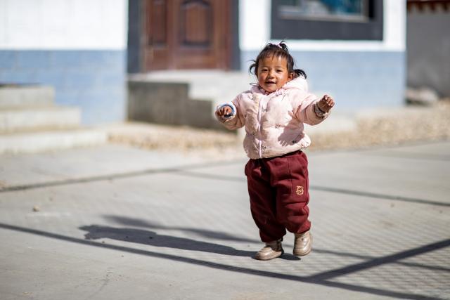 (260107) -- XIGAZE, Jan. 7, 2026 (Xinhua) -- A girl is pictured in Zimgag Village of Chamco Township, in Dingri County of Xigaze City, southwest China's Xizang Autonomous Region, on Jan. 5, 2026. In January 2025, a 6.8-magnitude earthquake struck Dingri County in the city of Xigaze, leveling thousands of houses.
  Ten months after the earthquake, more than 32,500 destroyed or damaged houses have been restored and handed over to affected residents. 
   In Zimgag Village, one of the villages hardest hit by the earthquake, new houses are neat and sturdy and supporting facilities are well-equipped. People live a stable and pleasant life here. (Xinhua/Sonam Dekyi)