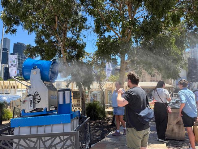 (260107) -- MELBOURNE, Jan. 7, 2026 (Xinhua) -- This photo taken with a mobile phone shows tourists at a mist cooling area at the Federation Square in Melbourne, Australia on Jan. 7, 2026. TO GO WITH "Heatwave sweeps S. Australia, triggering bushfire alerts" (Xinhua/Xu Haijing)