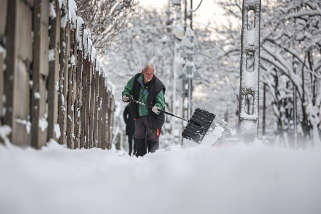 (260107) -- BUDAPEST, Jan. 7, 2026 (Xinhua) -- A man clears the snow on a street in Budapest, Hungary, Jan. 7, 2026. (Photo by David Balogh/Xinhua)