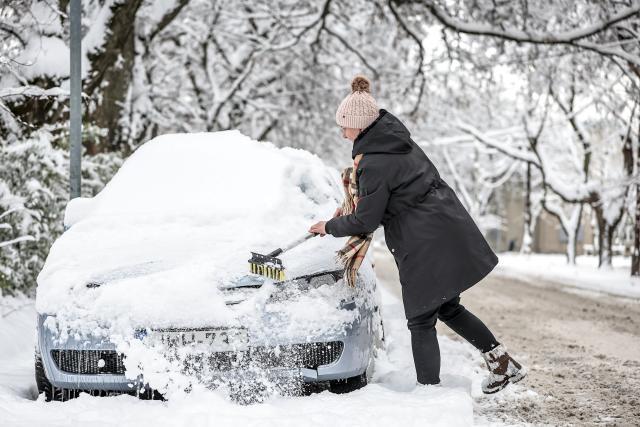 (260107) -- BUDAPEST, Jan. 7, 2026 (Xinhua) -- A woman clears the snow on a car in Budapest, Hungary on Jan. 7, 2026. (Photo by David Balogh/Xinhua)
