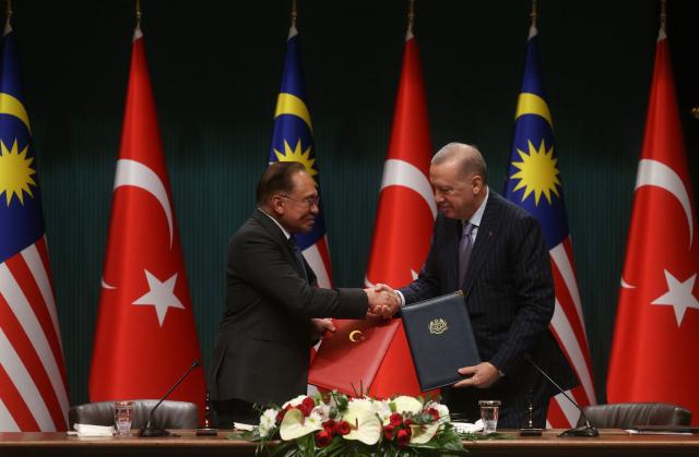 (260107) -- ANKARA, Jan. 7, 2026 (Xinhua) -- Turkish President Recep Tayyip Erdogan (R) and Malaysian Prime Minister Anwar Ibrahim exchange the signed agreement in Ankara, Türkiye, Jan. 7, 2026. Turkish President Recep Tayyip Erdogan and visiting Malaysian Prime Minister Anwar Ibrahim on Wednesday attended here the inaugural meeting of the Türkiye-Malaysia High-Level Strategic Cooperation Council, pledging to deepen collaboration in defense, trade and other key sectors. (Mustafa Kaya/Handout via Xinhua)
