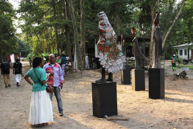 (260108) -- OUIDAH, Jan. 8, 2026 (Xinhua) -- Visitors view an artwork during the opening of an exhibition entitled "N.ART.UREL" in the Pahou Classified Forest, in Ouidah, Benin, on Jan. 7, 2026. The second edition of the group exhibition opened on Wednesday in the Pahou Classified Forest on the outskirts of Ouidah, a historic cultural city in Benin. Themed on "The Muses of the Forest," the exhibition brings together around 30 artists, showcasing a wide range of art forms including sculpture, installation and painting. (Photo by Seraphin Zounyekpe/Xinhua)