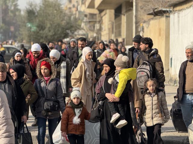 (260108) -- ALEPPO, Jan. 8, 2026 (Xinhua) -- This photo taken with a mobile phone shows civilians leaving areas in the Sheikh Maqsoud and Ashrafieh neighborhoods in Aleppo city, northern Syria, on Jan. 7, 2026. Crowds of residents were forced to flee the predominantly Kurdish neighborhoods of Sheikh Maqsoud and Ashrafieh in the northern city of Aleppo on Wednesday, as clashes flared between the Syrian army and the Kurdish-led Syrian Democratic Forces (SDF).
    As clashes intensified, Syrian authorities on Wednesday declared Sheikh Maqsoud and Ashrafieh closed military zones, imposed curfews, and opened designated humanitarian corridors for evacuation. Civil defense teams provided first aid and transport to shelters.
   TO GO WITH "Roundup: Renewed clashes in Syria's Aleppo force thousands to flee Kurdish districts" (Str/Xinhua)