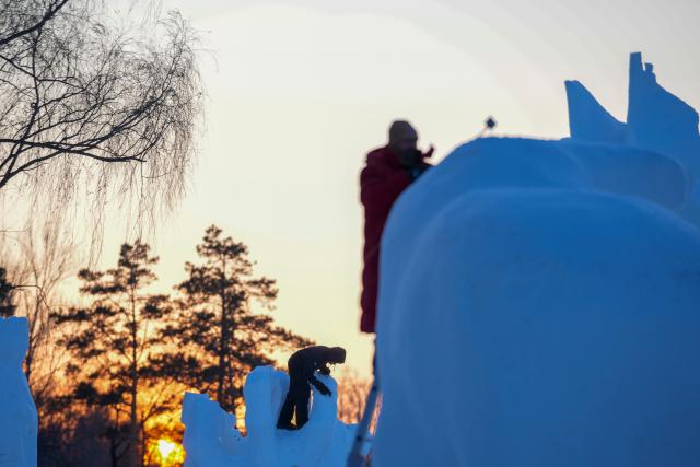 (260108) -- BEIJING, Jan. 8, 2026 (Xinhua) -- Contestants work on a snow sculpture at the compound for the Sun Island International Snow Sculpture Art Expo in Harbin, northeast China's Heilongjiang Province, Jan. 7, 2026. The 28th Harbin international snow sculpture competition kicked off here on Tuesday, attracting 25 teams of snow sculptors from 13 countries. (Xinhua/Wang Jianwei)