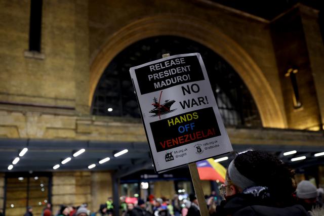 (260108) -- LONDON, Jan. 8, 2026 (Xinhua) -- A demonstrator holds a placard during a protest condemning U.S. attack on Venezuela outside King's Cross railway station in London, Britain, Jan. 7, 2026. (Xinhua/Li Ying)