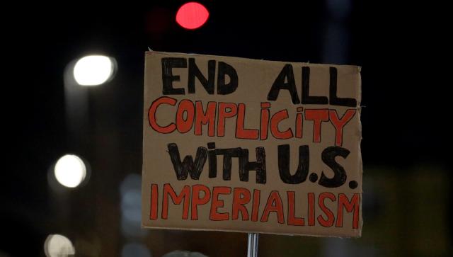 (260108) -- LONDON, Jan. 8, 2026 (Xinhua) -- A demonstrator holds a placard during a protest condemning U.S. attack on Venezuela outside King's Cross railway station in London, Britain, Jan. 7, 2026. (Xinhua/Li Ying)