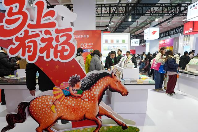 (260108) -- BEIJING, Jan. 8, 2026 (Xinhua) -- People read books at the 2026 Beijing Book Fair in Beijing, capital of China, Jan. 8, 2026. The 2026 Beijing Book Fair kicked off here on Thursday, with over 400,000 titles on display. This year's book fair features more than 10 themed zones as well as an exhibition area for various cultural products. (Xinhua/Ju Huanzong)