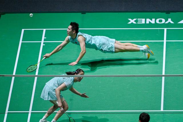 (260108) -- KUALA LUMPUR, Jan. 8, 2026 (Xinhua) -- Cheng Xing (top)/Zhang Chi of China compete during the mixed doubles round of 16 match against Feng Yanzhe/Huang Dongping of China at the Malaysia Open 2026 badminton tournament in Kuala Lumpur, Malaysia, Jan. 8, 2026. (Photo by Chong Voon Chung/Xinhua)