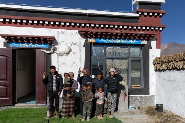 (260108) -- TINGRI, Jan. 8, 2026 (Xinhua) -- Cering Lhamo (2nd L), carrying her daughter in arms, poses for a photo with her family members in front of their new house in Tingri County of Xigaze, southwest China's Xizang Autonomous Region, on Jan. 5, 2026. In January 2025, a 6.8-magnitude earthquake struck Tingri County in Xigaze, leveling thousands of houses. Among those affected was Cering Lhamo, a young mother in Tonglai Village of Tingri County, who lost her 3-year-old child in the disaster.
  Within three days of the earthquake, Xizang launched a post-disaster reconstruction plan and began preliminary work, which included housing design, surveying and debris clearance. Just two months later, the reconstruction began.
  In October 2025, Cering Lhamo's new house has been completed and handed over. She was pregnant and was expecting in December. "When I give birth to my child, we will already be living in our new house," she said, hope glittering in her eyes.
   Now, one year after the earthquake, Cering Lhamo has embraced a new beginning. Her baby girl is one month old, and her older daughter, whom she was carrying in her arms after the earthquake hit, is running in their new house. (Xinhua/Jiang Fan)