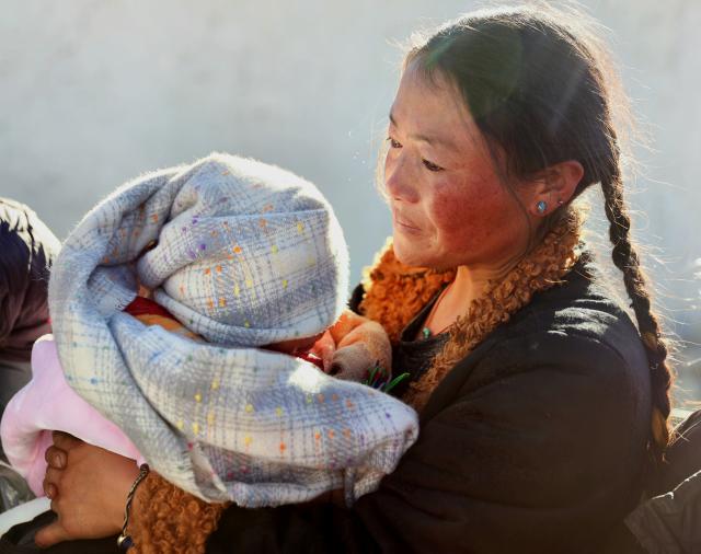 (260108) -- TINGRI, Jan. 8, 2026 (Xinhua) -- Cering Lhamo holds her one-month-old daughter after an earthquake hit in Tingri County of Xigaze City, southwest China's Xizang Autonomous Region, on Jan. 8, 2025. In January 2025, a 6.8-magnitude earthquake struck Tingri County in Xigaze, leveling thousands of houses. Among those affected was Cering Lhamo, a young mother in Tonglai Village of Tingri County, who lost her 3-year-old child in the disaster.
  Within three days of the earthquake, Xizang launched a post-disaster reconstruction plan and began preliminary work, which included housing design, surveying and debris clearance. Just two months later, the reconstruction began.
  In October 2025, Cering Lhamo's new house has been completed and handed over. She was pregnant and was expecting in December. "When I give birth to my child, we will already be living in our new house," she said, hope glittering in her eyes.
   Now, one year after the earthquake, Cering Lhamo has embraced a new beginning. Her baby girl is one month old, and her older daughter, whom she was carrying in her arms after the earthquake hit, is running in their new house. (Xinhua/Jiang Fan)