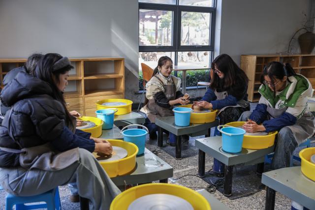 (260108) -- JINHUA, Jan. 8, 2026 (Xinhua) -- Tourists experience pottery making at a museum of ancient Wuzhou kiln pottery in Jindong District of Jinhua City, east China's Zhejiang Province, on Jan. 8, 2026. In recent years, Jindong District of Jinhua City has developed the cultural and tourism industry by leveraging its cultural, sports and music resources, creating new consumption scenarios for tourism with distinctive features, including sports parks, camping bases, old rural streets and ceramic art galleries. (Xinhua/Xu Yu)