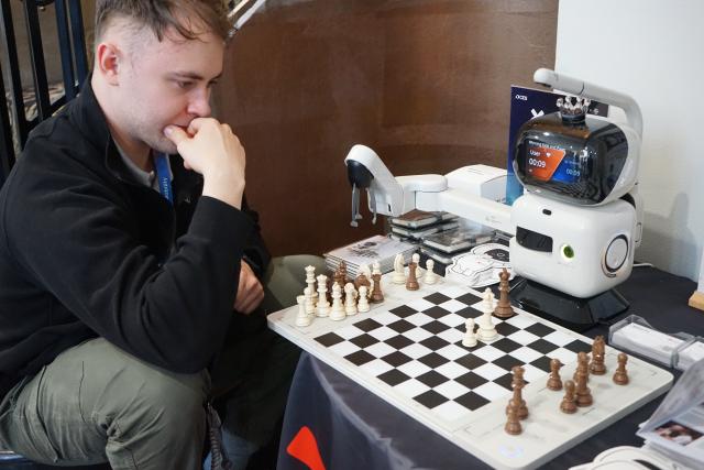 (260108) -- LAS VEGAS, Jan. 8, 2026 (Xinhua) -- A man plays chess with an AI-powered chess robot at the exhibition area of Chinese company SenseRobot at a pre-show event of the 2026 Consumer Electronics Show (CES) in Las Vegas, the United States, Jan. 5, 2026. TO GO WITH "Feature: Chinese innovators showcase smart home solutions at U.S. consumer show " (Photo by Zeng Hui/Xinhua)