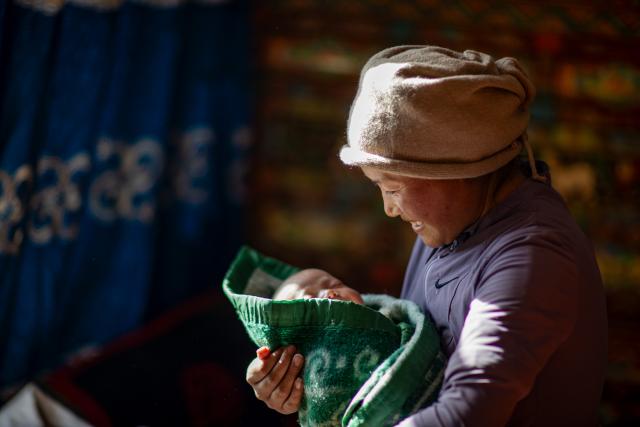 (260109) -- BEIJING, Jan. 9, 2026 (Xinhua) -- Cering Lhamo holds her one-month-old daughter Yanggim Lhamo in Tingri County of Xigaze City, southwest China's Xizang Autonomous Region, on Jan. 5, 2026.
  In January 2025, a 6.8-magnitude earthquake struck Tingri County in Xigaze, leveling thousands of houses. Among those affected was Cering Lhamo, a young mother in Tonglai Village of Tingri County, who lost her 3-year-old child in the disaster.
  Within three days of the earthquake, Xizang launched a post-disaster reconstruction plan and began preliminary work, which included housing design, surveying and debris clearance. Just two months later, the reconstruction began.
  In October 2025, Cering Lhamo's new house has been completed and handed over. She was pregnant and was expecting in December. "When I give birth to my child, we will already be living in our new house," she said, hope glittering in her eyes.
   Now, one year after the earthquake, Cering Lhamo has embraced a new beginning. Her baby girl is one month old, and her older daughter, whom she was carrying in her arms after the earthquake hit, is running in their new house. (Xinhua/Jiang Fan)