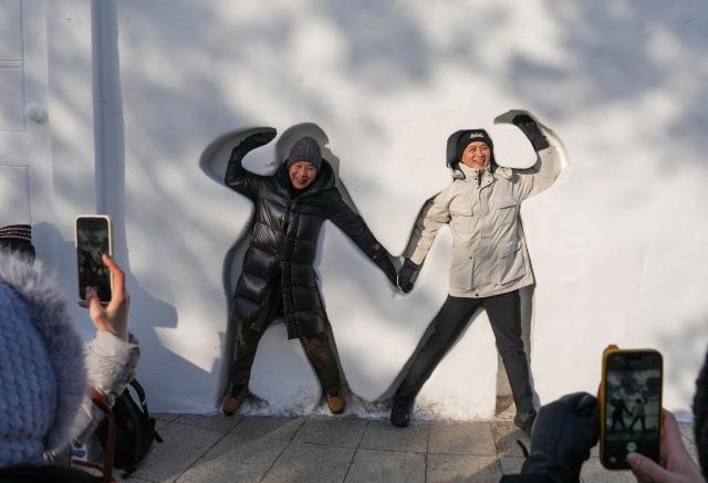 (260109) -- HARBIN, Jan. 9, 2026 (Xinhua) -- Tourists pose for photos while visiting the 38th Sun Island International Snow Sculpture Art Expo in Harbin, northeast China's Heilongjiang Province, Jan. 6, 2026.
  The ongoing snow sculpture art expo, with an exhibition area of 1.5 million square meters, is attracting visitors to its stunning ice and snow landscapes. (Xinhua/Wang Jianwei)