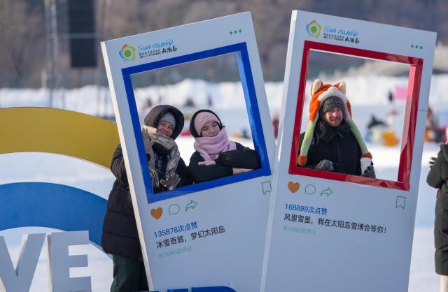 (260109) -- HARBIN, Jan. 9, 2026 (Xinhua) -- Foreign tourists pose for photos while visiting the 38th Sun Island International Snow Sculpture Art Expo in Harbin, northeast China's Heilongjiang Province, Jan. 8, 2026.
  The ongoing snow sculpture art expo, with an exhibition area of 1.5 million square meters, is attracting visitors to its stunning ice and snow landscapes. (Xinhua/Wang Jianwei)