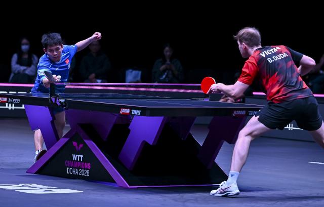 (260109) -- DOHA, Jan. 9, 2026 (Xinhua) -- Lin Shidong (L) of China hits a return during the men's singles Round of 16 match against Benedikt Duda of Germany at the WTT Champions Doha 2026 in Doha, Qatar, Jan. 9, 2026. (Photo by Nikku/Xinhua)