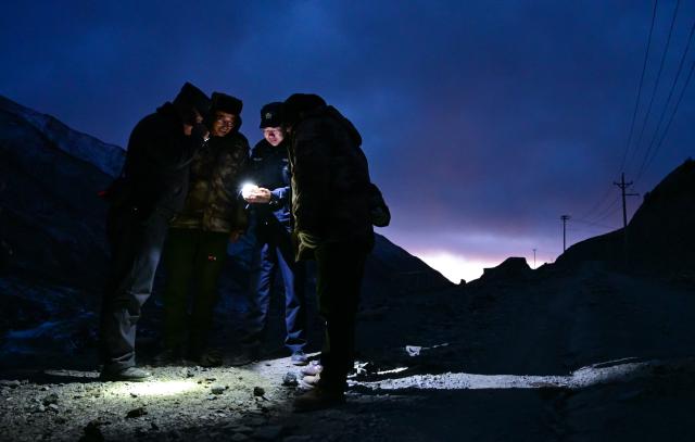 (260109) -- MENYUAN, Jan. 9, 2026 (Xinhua) -- Police officers communicate with rangers during a patrol in the Laohugou region of Menyuan Hui Autonomous County in Haibei Tibetan Autonomous Prefecture, northwest China's Qinghai Province, Jan. 8, 2026. For years, police officers and rangers inside Qilian Mountain National Park in northwest China's Qinghai Province have dedicated themselves to their work, carrying out regular patrols and safeguarding the region's ecological security despite high altitude and harsh winter weather. (Xinhua/Qi Zhiyue)