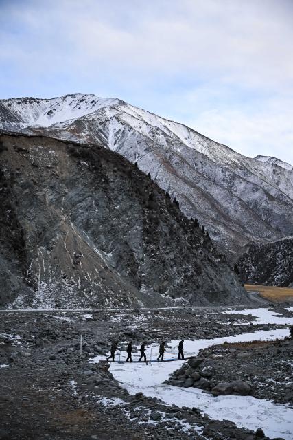 (260109) -- MENYUAN, Jan. 9, 2026 (Xinhua) -- Police officers and rangers patrol the Qilian Mountains in the Laohugou region of Menyuan Hui Autonomous County in Haibei Tibetan Autonomous Prefecture, northwest China's Qinghai Province, Jan. 8, 2026. For years, police officers and rangers inside Qilian Mountain National Park in northwest China's Qinghai Province have dedicated themselves to their work, carrying out regular patrols and safeguarding the region's ecological security despite high altitude and harsh winter weather. (Xinhua/Zhang Long)
