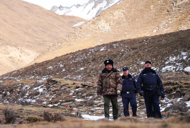 (260109) -- MENYUAN, Jan. 9, 2026 (Xinhua) -- Police officers Wei Lei (C), Guo Jianye (R) and ranger Li Zhanyun (L) patrol the Qilian Mountains in the Laohugou region of Menyuan Hui Autonomous County in Haibei Tibetan Autonomous Prefecture, northwest China's Qinghai Province, Jan. 8, 2026. For years, police officers and rangers inside Qilian Mountain National Park in northwest China's Qinghai Province have dedicated themselves to their work, carrying out regular patrols and safeguarding the region's ecological security despite high altitude and harsh winter weather. (Xinhua/Qi Zhiyue)