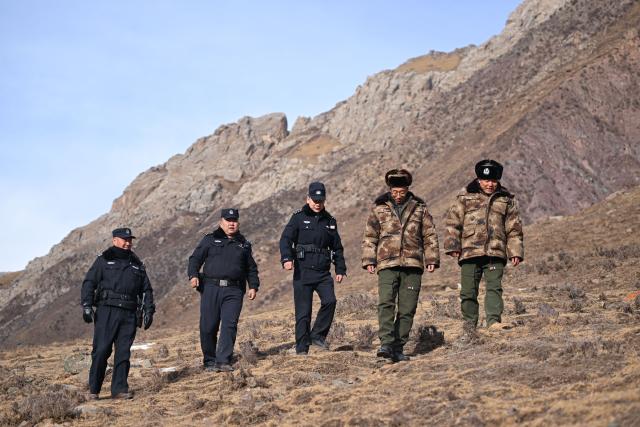 (260109) -- MENYUAN, Jan. 9, 2026 (Xinhua) -- Police officers and rangers patrol the Qilian Mountains in the Laohugou region of Menyuan Hui Autonomous County in Haibei Tibetan Autonomous Prefecture, northwest China's Qinghai Province, Jan. 8, 2026. For years, police officers and rangers inside Qilian Mountain National Park in northwest China's Qinghai Province have dedicated themselves to their work, carrying out regular patrols and safeguarding the region's ecological security despite high altitude and harsh winter weather. (Xinhua/Zhang Long)