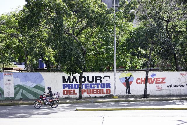 (260109) -- CARACAS, Jan. 9, 2026 (Xinhua) -- A man riding a motorcycle passes by a graffiti wall in Caracas, Venezuela, Jan. 8, 2026. (Xinhua/Ding Hongfa)