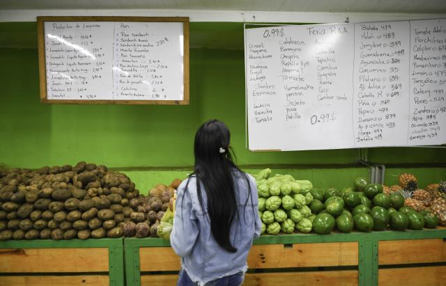 (260109) -- CARACAS, Jan. 9, 2026 (Xinhua) -- A customer checks the price of goods in a store in Caracas, Venezuela, Jan. 9, 2026. (Xinhua/Ding Hongfa)