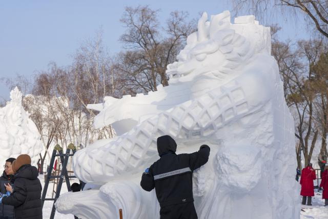 (260110) -- HARBIN, Jan. 10, 2026 (Xinhua) -- A Chinese contestant creates his snow sculpture at the venue of Sun Island Snow Expo in Harbin, northeast China's Heilongjiang Province, Jan. 9, 2026. A four-day snow sculpture competition concluded here on Friday, with the participation of 25 teams from 13 countries. (Xinhua/Wang Song)