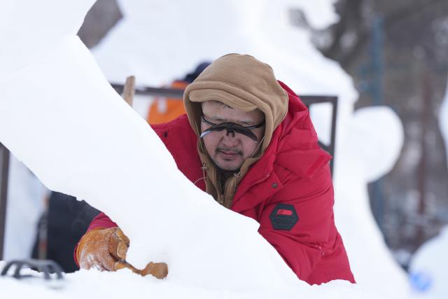 (260110) -- HARBIN, Jan. 10, 2026 (Xinhua) -- A contestant creates his snow sculpture at the venue of Sun Island Snow Expo in Harbin, northeast China's Heilongjiang Province, Jan. 9, 2026. A four-day snow sculpture competition concluded here on Friday, with the participation of 25 teams from 13 countries. (Xinhua/Wang Song)