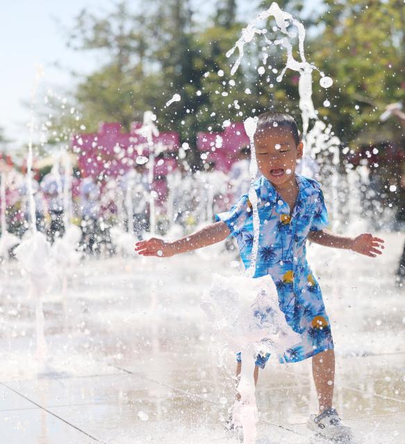 (260110) -- SANYA, Jan. 10, 2026 (Xinhua) -- A boy plays with water at a fountain in the Nanshan Cultural Tourism Zone in Sanya, south China's Hainan Province, on Jan. 9, 2026. (Photo by Chen Wenwu/Xinhua)