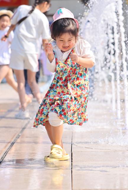 (260110) -- SANYA, Jan. 10, 2026 (Xinhua) -- A girl plays with water at a fountain in the Nanshan Cultural Tourism Zone in Sanya, south China's Hainan Province, on Jan. 9, 2026. (Photo by Chen Wenwu/Xinhua)