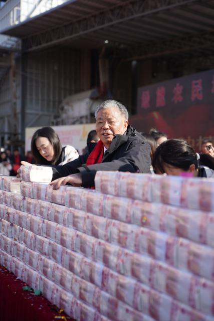 (260110) -- NANCHANG, Jan. 10, 2026 (Xinhua) -- Ling Jihe arranges stacks of cash for distribution in Anyi County of Nanchang City, east China's Jiangxi Province, Jan. 9, 2026. Ling Jihe, a rural entrepreneur in Anyi County, distributed year-end bonuses totaling 21.29 million yuan (about 3.05 million U.S. dollars) to his team on Friday, extending his 15-year tradition of rewarding outstanding farmers.
   Since founding an agricultural company in 2010, Ling has been hiring local farmers to cultivate land under the company's management. Farmers receive a basic monthly salary in advance, with year-end bonuses tied to annual output performance. The company also provides a full range of services including seed selection, sowing, weeding and harvesting. In 2025, Ling's team achieved a grain output of 63.5 million kilograms. (Xinhua/Zhou Mi)