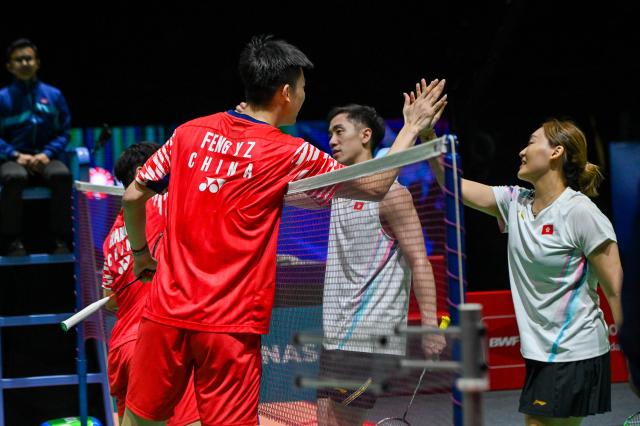(260110) -- KUALA LUMPUR, Jan. 10, 2026 (Xinhua) -- Feng Yanzhe (L, front)/Huang Dongping (L, back) of China give Tang Chun Man/Tse Ying Suet of China's Hong Kong a high five after their mixed doubles semifinal match at the Malaysia Open 2026 badminton tournament in Kuala Lumpur, Malaysia, Jan. 10, 2026. (Photo by Chong Voon Chung/Xinhua)