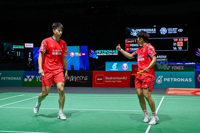 (260110) -- KUALA LUMPUR, Jan. 10, 2026 (Xinhua) -- Feng Yanzhe/Huang Dongping (R) of China celebrate a score during the mixed doubles semifinal match against Tang Chun Man/Tse Ying Suet of China's Hong Kong at the Malaysia Open 2026 badminton tournament in Kuala Lumpur, Malaysia, Jan. 10, 2026. (Photo by Chong Voon Chung/Xinhua)