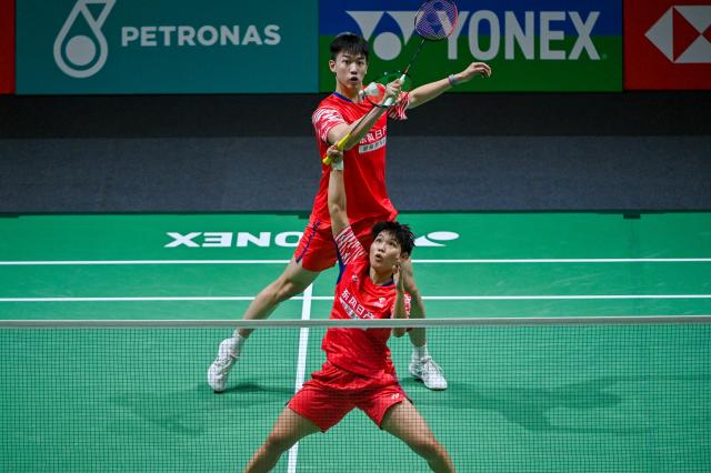 (260110) -- KUALA LUMPUR, Jan. 10, 2026 (Xinhua) -- Feng Yanzhe/Huang Dongping (bottom) of China compete during the mixed doubles semifinal match against Tang Chun Man/Tse Ying Suet of China's Hong Kong at the Malaysia Open 2026 badminton tournament in Kuala Lumpur, Malaysia, Jan. 10, 2026. (Photo by Chong Voon Chung/Xinhua)