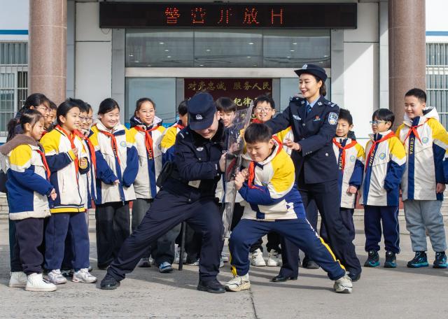 (260110) -- BEIJING, Jan. 10, 2026 (Xinhua) -- A drone photo shows a pupil experiencing a confrontation against a police officer holding police equipment in Taizhou, east China's Jiangsu Province, Jan. 10, 2026. Various activities were held nationwide to mark the sixth Chinese People's Police Day. (Photo by Tang Dehong/Xinhua)