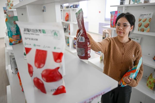 (260110) -- MOYU, Jan. 10, 2026 (Xinhua) -- A staff member arranges products to be displayed in live-streaming at a network technology company in Moyu County, Hotan Prefecture, northwest China's Xinjiang Uygur Autonomous Region, Jan. 9, 2026. Premium Xinjiang goods like walnuts and red jujubes, which are popular choices for customers nationwide for the Chinese New Year, have entered their peak sales season as the Spring Festival approaches. E-commerce companies in Hotan are leveraging live-streaming sales and online shopping festivals to promote high-quality agricultural products of Xinjiang, boosting farmers' incomes and rural revitalization. (Xinhua/Ding Lei)
