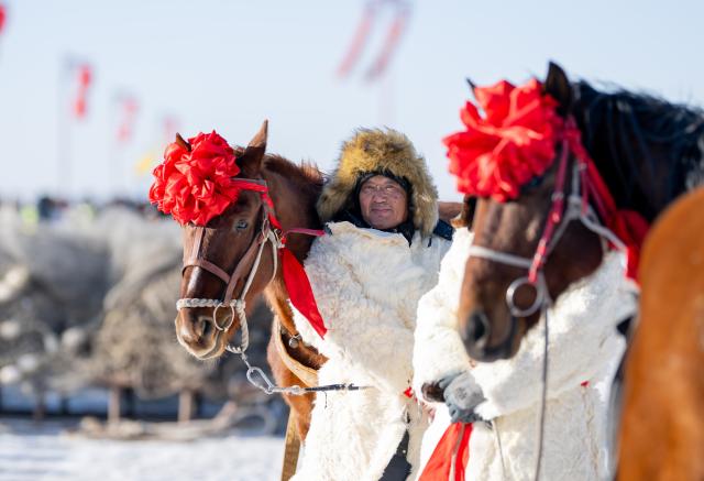 (260110) -- HOHHOT, Jan. 10, 2026 (Xinhua) -- Fishermen wait for hauling the fishing net during the 4th Hasuhai Lake winter fishing festival in Tumd Left Banner of Hohhot, north China's Inner Mongolia Autonomous Region, Jan. 10, 2026. The 4th Hasuhai Lake winter fishing festival opened in Tumd Left Banner of Hohhot on Saturday. The activity features ice and snow entertainment, hot spring experience, delicious food and folk shows, attracting many citizens and tourists. (Xinhua/Lian Zhen)