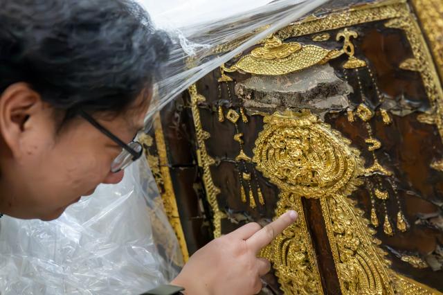 (260110) -- WUHAN, Jan. 10, 2026 (Xinhua) -- A staff member checks a cultural relic at the cultural relics protection center in Jingzhou, central China's Hubei Province, Jan. 9, 2026. Organic cultural relics represented by bamboo slips pose significant challenges in cultural relic preservation. In recent years, the cultural relics protection center in Jingzhou of Hubei Province has focused on innovation and application of preservation techniques for organic cultural relics, striving to ensure comprehensive care for such items. (Xinhua/Du Zixuan)