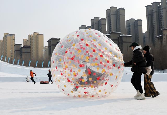(260110) -- SHENYANG, Jan. 10, 2026 (Xinhua) -- Visitors play on snow at a hot spring resort in Shenyang, northeast China's Liaoning Province, Jan. 9, 2026. Leveraging its unique natural resources, Shenyang offers special winter tourism experiences by combining ice-and-snow activities with hot springs, attracting visitors from across the country. (Xinhua/Li Gang)