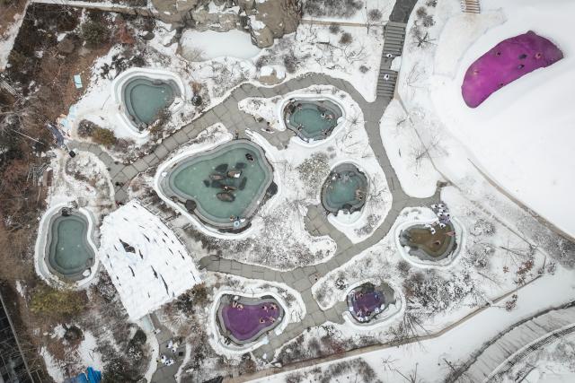 (260110) -- SHENYANG, Jan. 10, 2026 (Xinhua) -- An aerial drone photo shows visitors enjoying outdoor hot spring surrounded by ice and snow at a hot spring resort in Shenyang, northeast China's Liaoning Province, Jan. 9, 2026. Leveraging its unique natural resources, Shenyang offers special winter tourism experiences by combining ice-and-snow activities with hot springs, attracting visitors from across the country. (Xinhua/Pan Yulong)