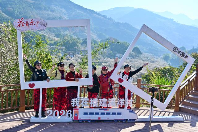 (260110) -- YONGTAI, Jan. 10, 2026 (Xinhua) -- Tourists pose for photos in Yongtai County, southeast China's Fujian Province, Jan. 10, 2026. The annual plum blossom festival kicked off here on Saturday and is expected to promote local tourism and present the natural beauty of the county through various cultural activities. (Xinhua/Jiang Kehong)