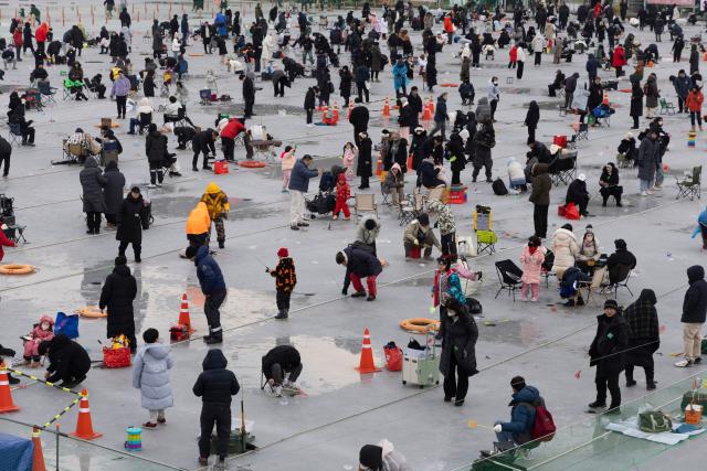 (260110) -- HWACHEON, Jan. 10, 2026 (Xinhua) -- Tourists fish on a frozen river during the Hwacheon Sancheoneo Ice Festival in Hwacheon-gun, South Korea, Jan. 10, 2026. (Photo by Jun Hyosang/Xinhua)