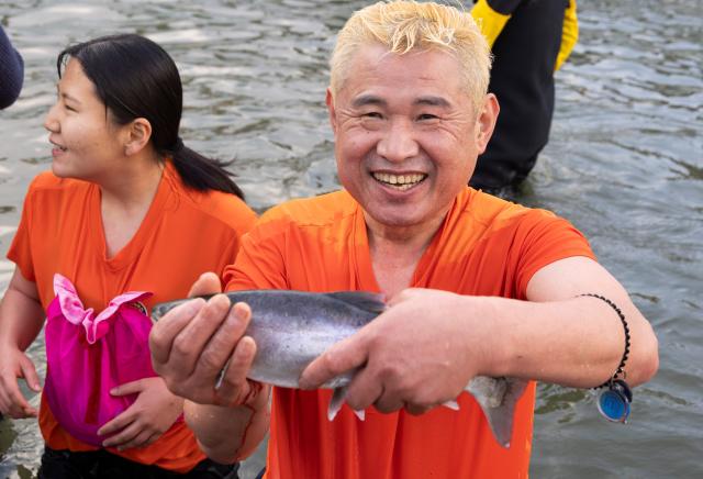 (260110) -- HWACHEON, Jan. 10, 2026 (Xinhua) -- A man catches fish with bare hands during the Hwacheon Sancheoneo Ice Festival in Hwacheon-gun, South Korea, Jan. 10, 2026. (Photo by Jun Hyosang/Xinhua)